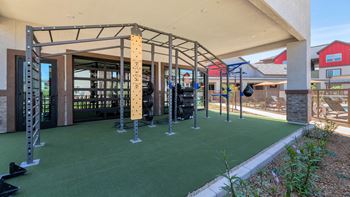 A fitness center with weights and equipment and a building with a patio